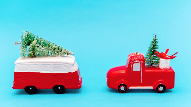 圣诞树两辆红白相间的玩具车 上面有圣诞树蓝色背景圣诞树圣诞节圣诞装饰