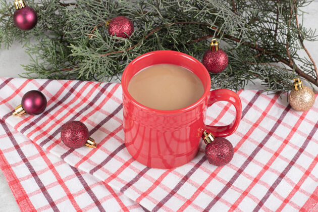 咖啡桌布上的红色咖啡杯 有圣诞球和松枝装饰营养食品