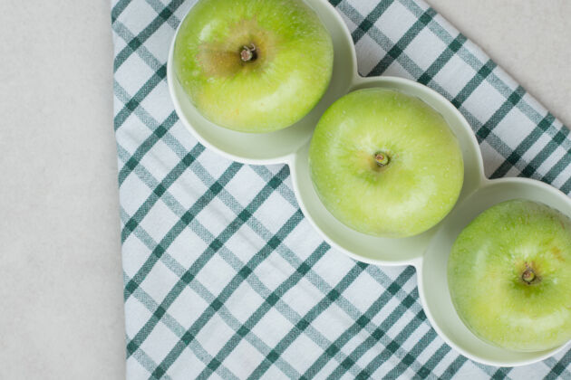 水果整个青苹果放在白板上 还有条纹桌布可口有机膳食