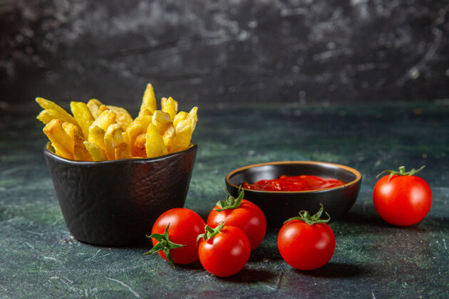 胡椒前视图美味的炸薯条和樱桃番茄在黑暗的表面食品水果樱桃