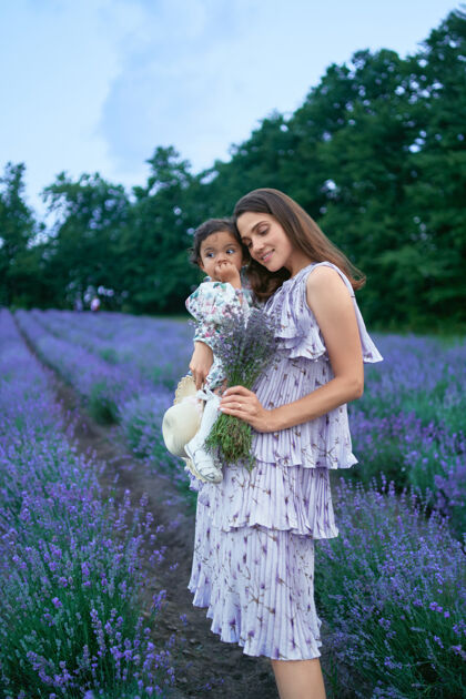 花妈妈抱着小女儿和薰衣草花束微笑花束薰衣草
