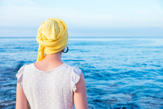 材料戴着黄领巾的女人在欣赏海景疾病考试温暖