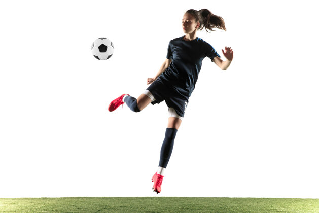姿势年轻的女性足球运动员或足球运动员 长发 运动服和靴子 在白色背景上为目标踢球健康的生活方式 职业体育 爱好的概念玩球员运动