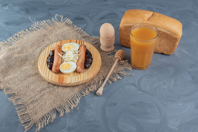 美味什锦早餐盘旁边的面包 桃子汁 煮鸡蛋和蜂蜜勺大理石桌上美味早餐美味