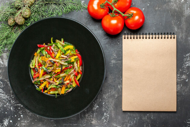 厨具黑色表面上美味蔬菜沙拉的俯视图新鲜西红柿菜肴