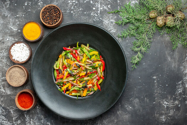 食物黑色表面上美味蔬菜沙拉的俯视图健康美味蔬菜沙拉肉