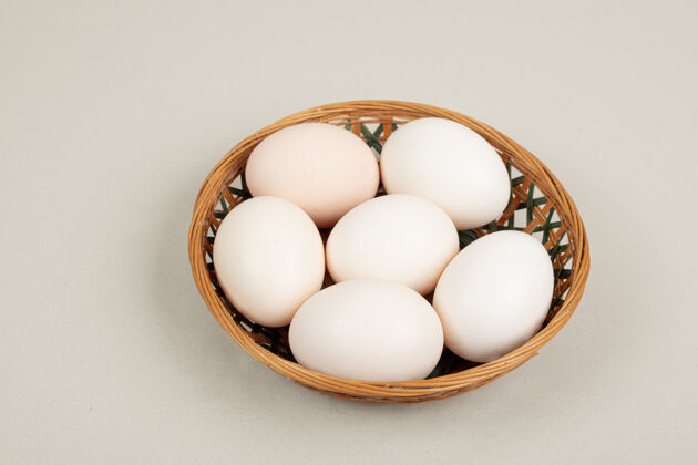 家禽柳条筐上放着新鲜的鸡蛋未料理的生的鸡蛋