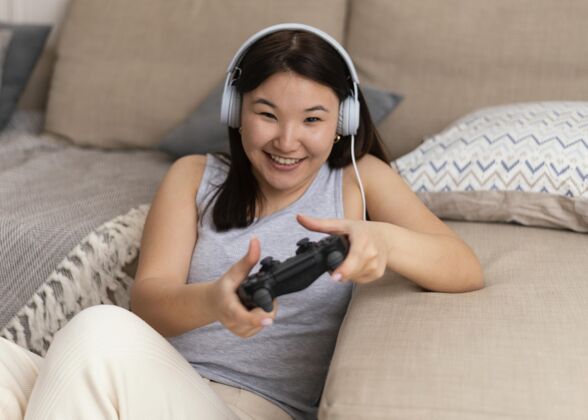 耳机中枪笑脸女人玩电子游戏设备玩家控制器