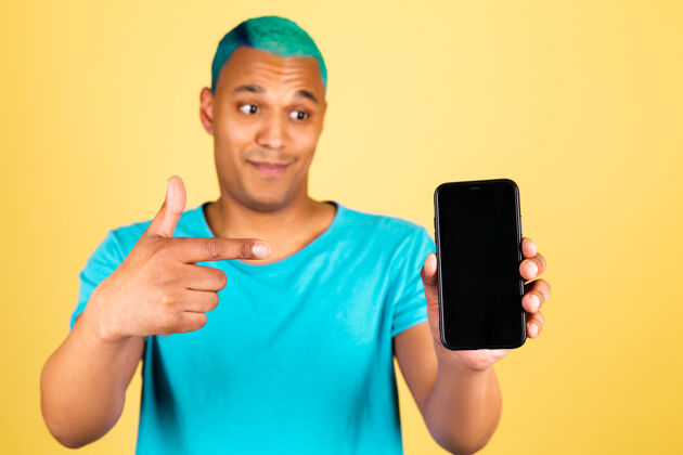 家伙黑人非洲男人在休闲的黄色墙上用手机积极的快乐点食指在黑色的空屏幕上点人男人