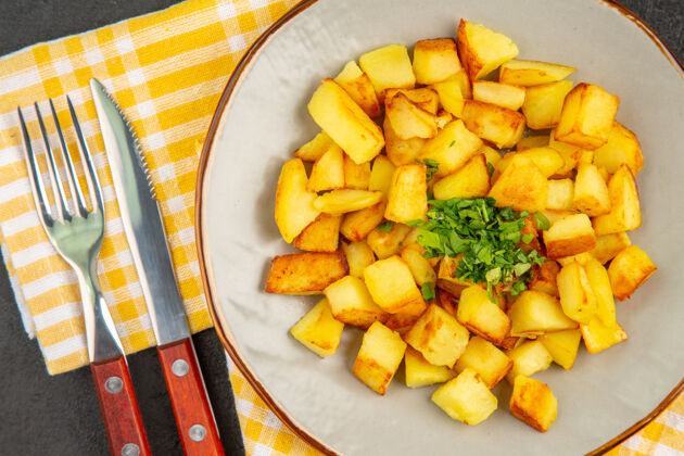 午餐在深灰色表面的盘子里 美味的炸土豆俯视图土豆农产品烹饪