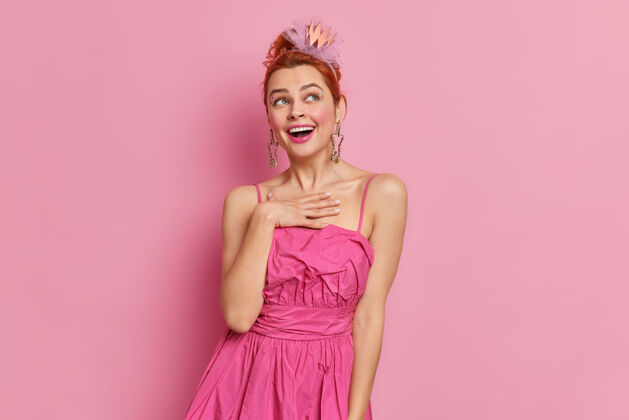白种人室内拍摄的红发美女开心地笑着把手放在胸前粉色乐趣姿势