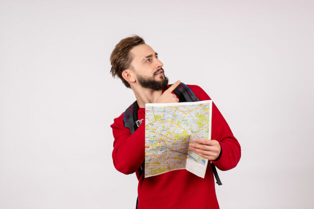 颜色正面图年轻男性游客背着背包在白墙飞机上探索地图城市度假情感人文旅游路线路线背包男人