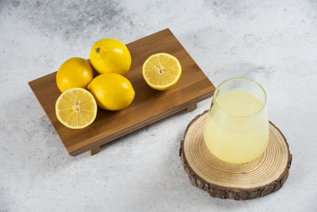 黄色在木板上放一杯新鲜的柠檬汁凉果汁水