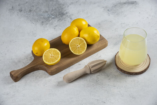 餐桌在木板上放一杯新鲜的柠檬汁柠檬冷黄色