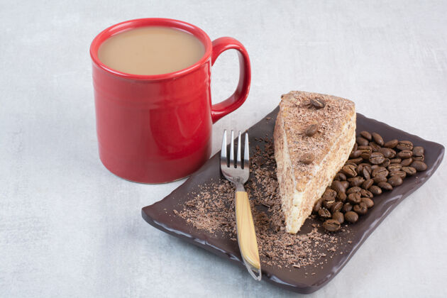 盘子一片蛋糕加咖啡豆和一杯咖啡叉子豆子咖啡