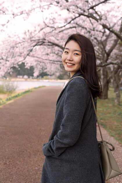 日本笑脸女人在公园里散步日本樱花花