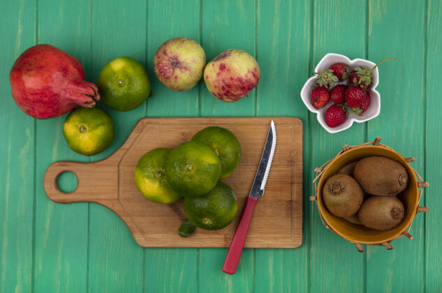苹果用刀在砧板上切橘子 石榴 苹果 猕猴桃和草莓顶部柑橘新鲜