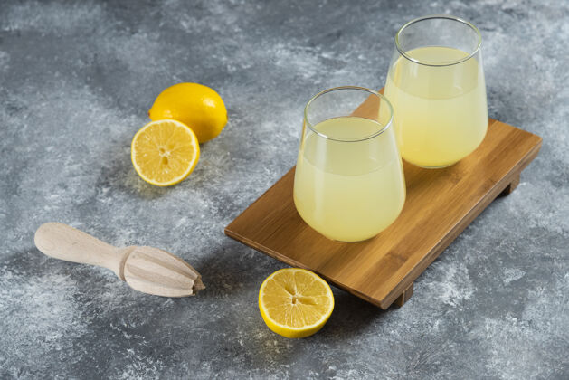 果汁杯子里装满了柠檬水 还有柠檬片和木铰刀玻璃柠檬凉的