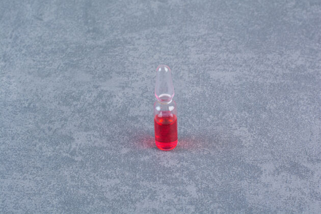 剂量大理石表面的红色医用安瓿液体安瓿满的