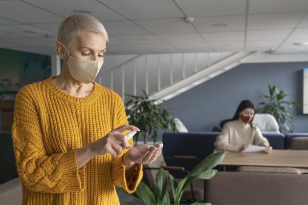 面罩戴着医用面罩上班的女人专业工作办公室