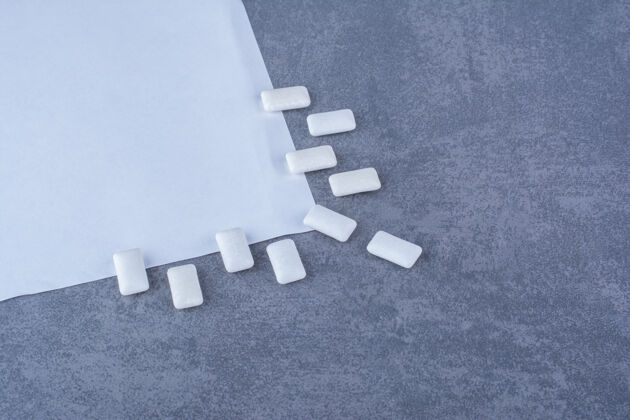 含糖口香糖装饰性地排列在大理石表面的一张纸的边缘整理纸泡泡糖