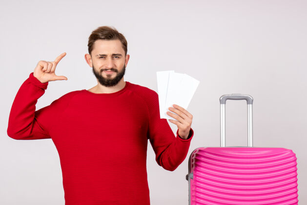 成人正面图：年轻男性 带着粉红色的包 拿着白墙上的票 彩色的旅行 度假 飞行 旅游风景男人年轻男性