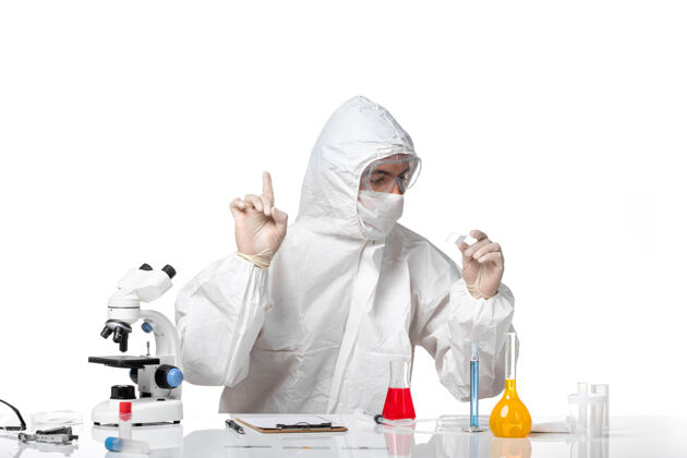 病毒正面图：男医生穿着防护服 戴着面罩 因为科维德在白色空间工作医学化学工作
