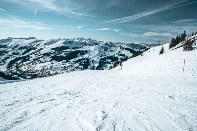 阳光从山顶鸟瞰奥地利的雪山范围冷雪