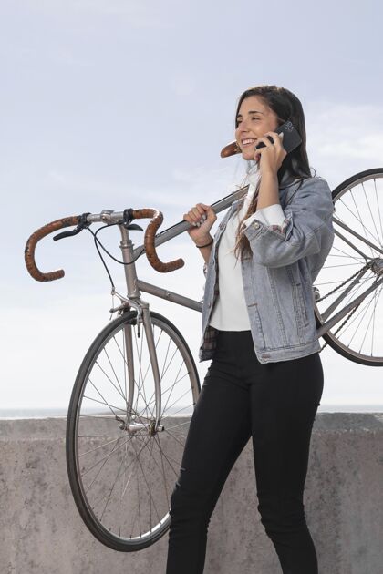 环保在自行车旁打电话的年轻女子积极城市个人