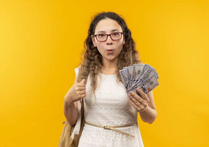 眼镜印象深刻的年轻漂亮的女学生戴着眼镜 背着一个袋子 手里拿着黄色的钱钱年轻抱