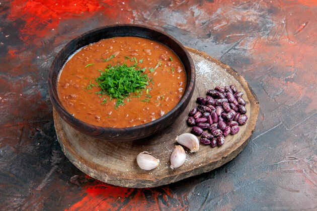 餐厅番茄汤豆蒜的侧视图放在木砧板上的混色桌上碗豆类晚餐