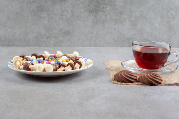 茶一盘糖果和巧克力蘑菇旁边的一杯茶和饼干大理石背景高品质的照片巧克力甜点小吃