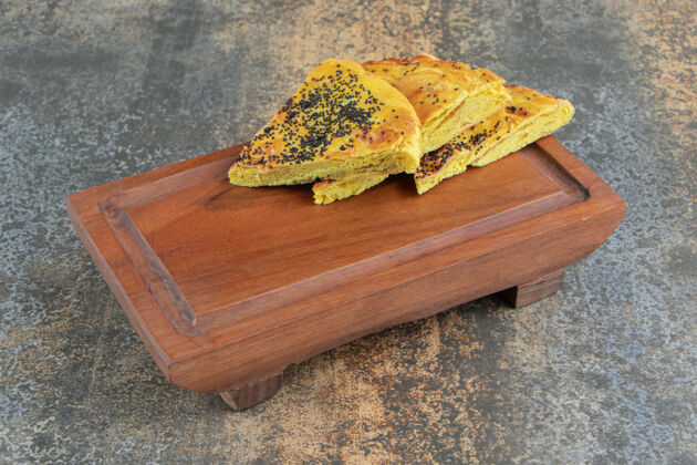 糕点在木板上放的三角形糕点餐罂粟块