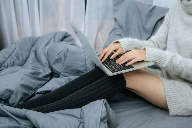 工作在寒冷的日子里 在床上用笔记本电脑工作的女人温暖活跃床