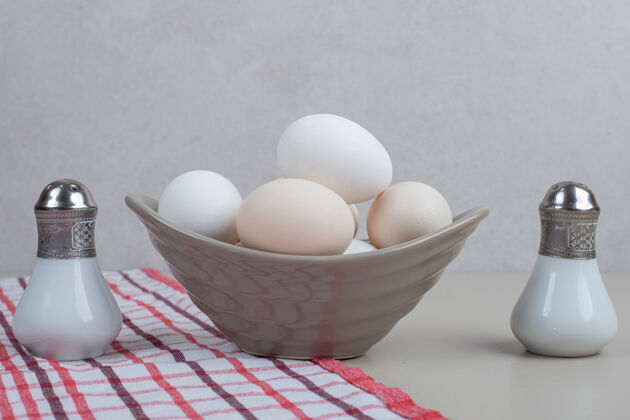 新鲜几只新鲜的鸡蛋放在桌布上的灰色盘子里未经料理的食物桌布