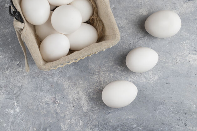 木头装满新鲜鸡蛋的篮子放在大理石上食物营养白