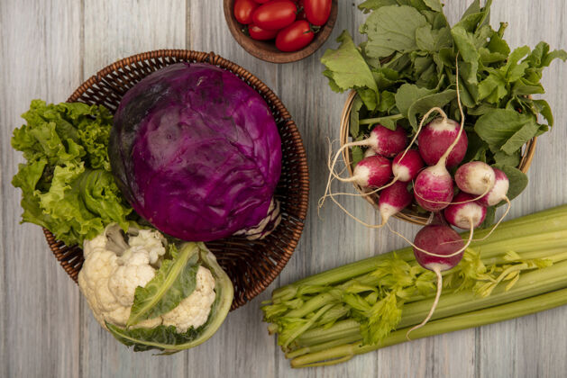 西红柿新鲜蔬菜的顶视图 如花椰菜紫色卷心菜和生菜放在桶上 萝卜放在桶上 西红柿放在木碗上 芹菜放在灰色的木制背景上木材灰色芹菜