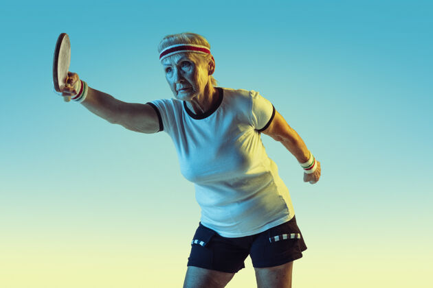 运动资深女子乒乓球运动服装训练在梯度背景下 霓虹灯女模特在伟大的形状保持活跃概念的运动 活动 运动 幸福 信心复制空间比赛业余人