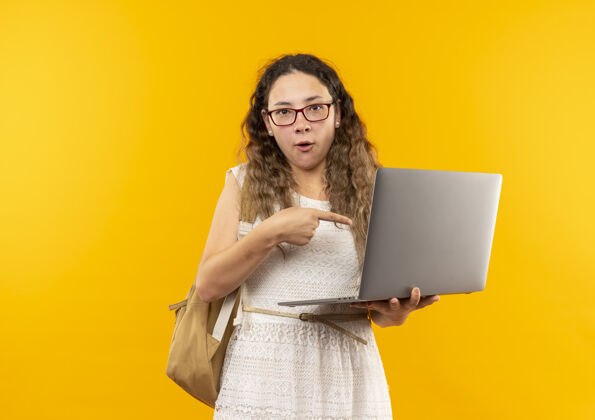 眼镜年轻漂亮的女学生戴着眼镜 背着书包拿着笔记本电脑 指着黄色的笔记本电脑年轻女学生拿着