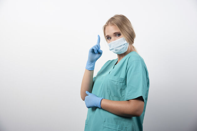 成人女医生竖起大拇指 戴着医用口罩高质量照片专家医学防护工作服