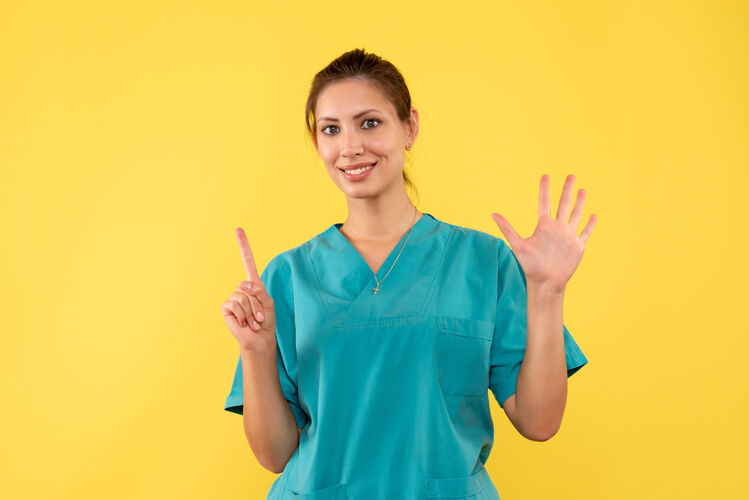 休闲前视图黄色背景上穿着医用衬衫的女医生医疗健康护士