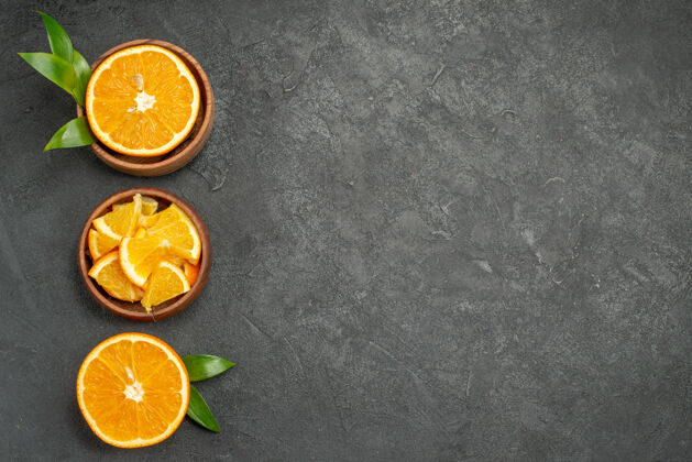 甜橙一套切成两半片的鲜橙叶和鲜花放在黑桌子上切片水果