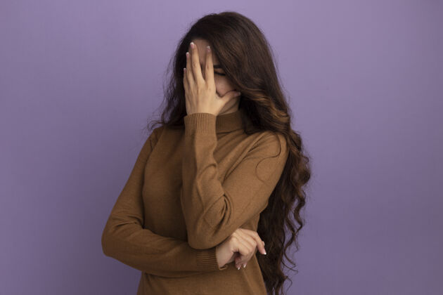 不舒服年轻漂亮的姑娘穿着棕色高领毛衣 脸上蒙着紫色的隔离墙高领毛衣女孩封面