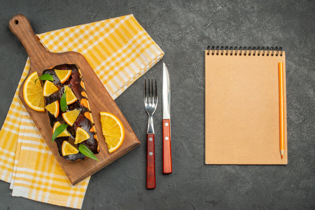 黑板在笔记本旁边的绿色条状毛巾上放上松软的蛋糕和柠檬叶剪纸空白钢笔