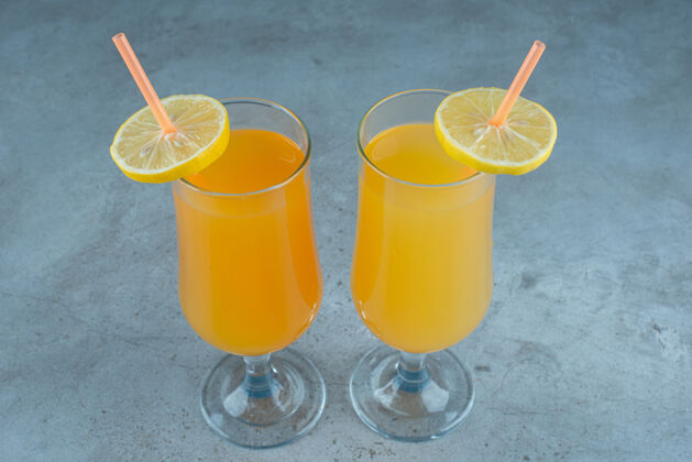 玻璃器皿两杯新鲜果汁装在一个装有吸管的杯子里素食液体水果
