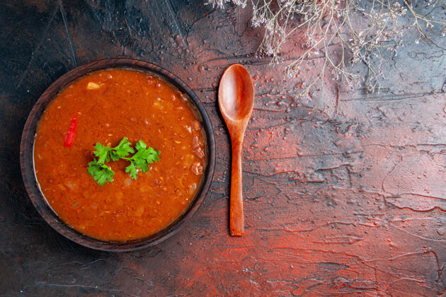 木勺在一个棕色碗和调羹的混合色桌子上的经典番茄汤的水平视图勺子番茄汤餐具