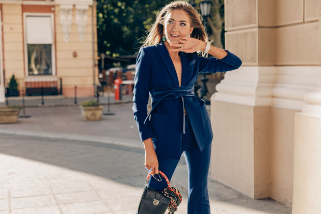 包优雅迷人的女人穿着蓝色时髦的西装拿着手提包走在街上华丽衣服人