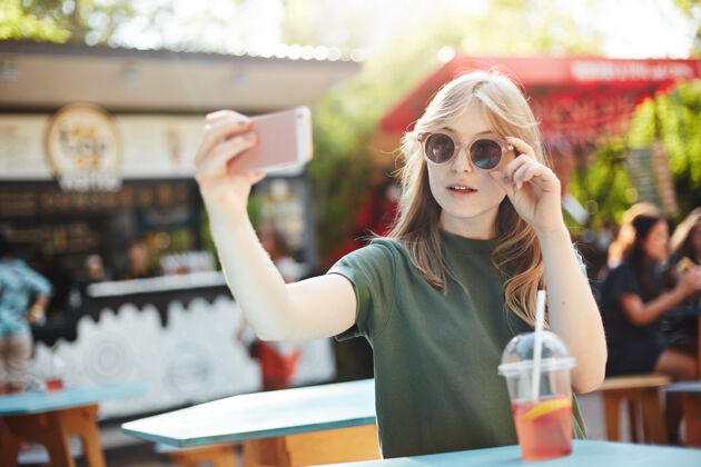 公园一位金发碧眼 满脸雀斑的女士戴着眼镜自拍 在公园的一个夏日里发布在社交媒体上休息午餐咖啡馆