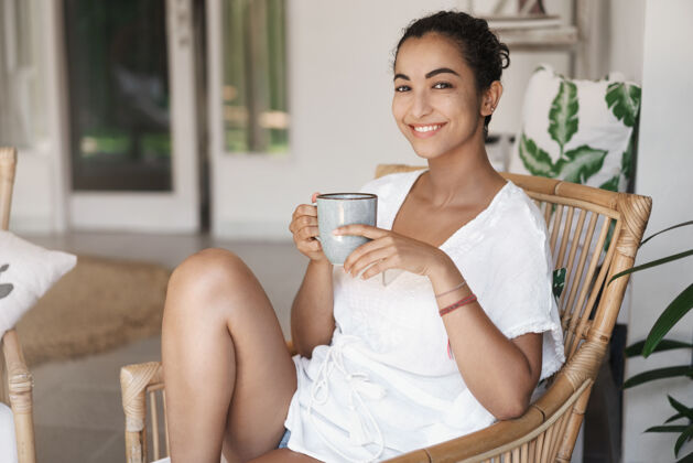 周末温柔放松的女人坐在藤条扶手椅上享受着咖啡咖啡放松茶