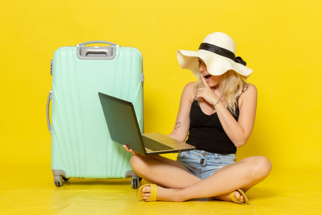视图正面图年轻女性用笔记本电脑上的黄墙女孩远航度假旅行阳光笔记本电脑工人年轻人